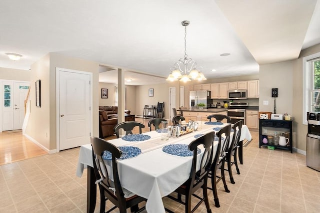 dining area with baseboards and an inviting chandelier