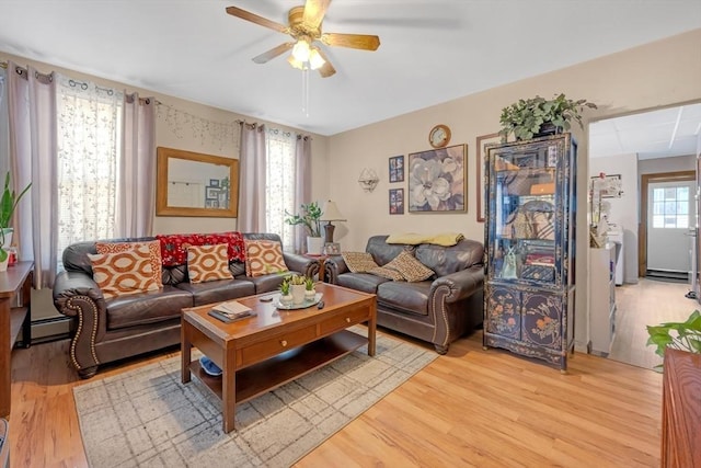 living room with ceiling fan, a baseboard heating unit, and light wood-style floors
