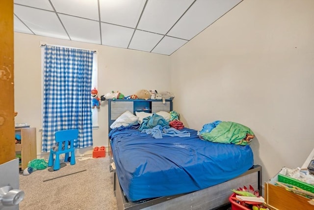 bedroom featuring carpet floors and a drop ceiling