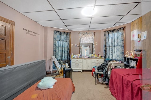 carpeted bedroom featuring a drop ceiling