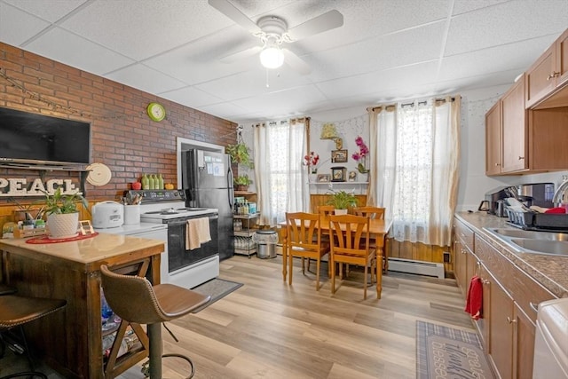 kitchen featuring brick wall, a ceiling fan, a drop ceiling, a baseboard radiator, and white electric range