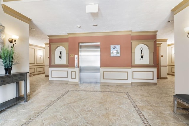 interior space featuring crown molding, baseboards, a decorative wall, and elevator