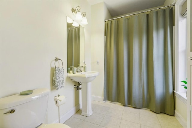 full bath featuring baseboards, a sink, tile patterned floors, and toilet