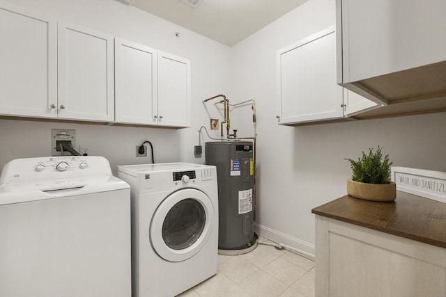 laundry area with light tile patterned flooring, baseboards, electric water heater, cabinet space, and independent washer and dryer