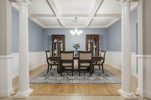 tiled dining room featuring decorative columns, a chandelier, coffered ceiling, and beamed ceiling