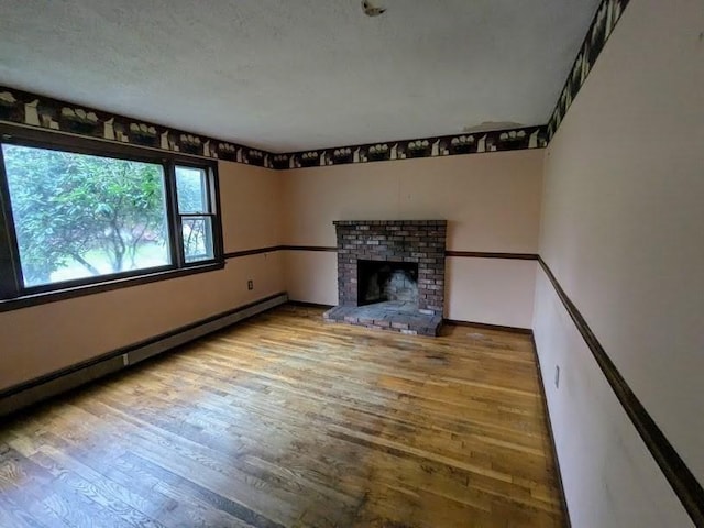 14 Reagan Rd, Townsend, MA 01469 - unfurnished living room with wood finished floors, baseboard heating, a fireplace, and baseboards
