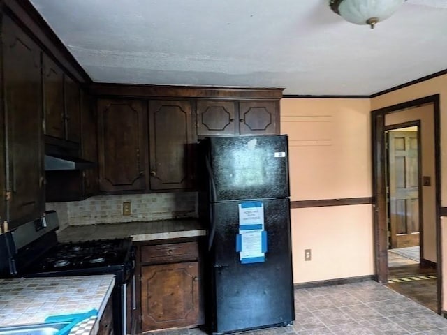 14 Reagan Rd, Townsend, MA 01469 - kitchen with freestanding refrigerator, gas range, dark brown cabinetry, tasteful backsplash, and tile counters