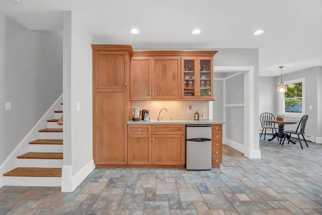 bar featuring baseboards, a sink, stairway, and decorative backsplash