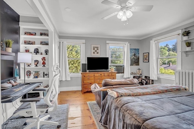 bedroom featuring light wood-style floors, radiator heating unit, ornamental molding, and baseboards