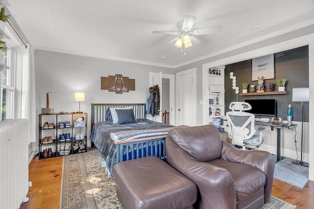 bedroom featuring radiator heating unit, ornamental molding, and wood finished floors