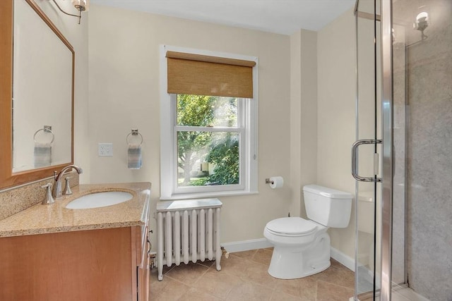 bathroom with radiator, toilet, a stall shower, vanity, and baseboards