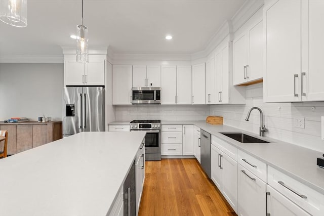2 Rockwood Ter Unit 2, Newton, MA 02466 - kitchen with stainless steel appliances, a sink, crown molding, light countertops, and tasteful backsplash