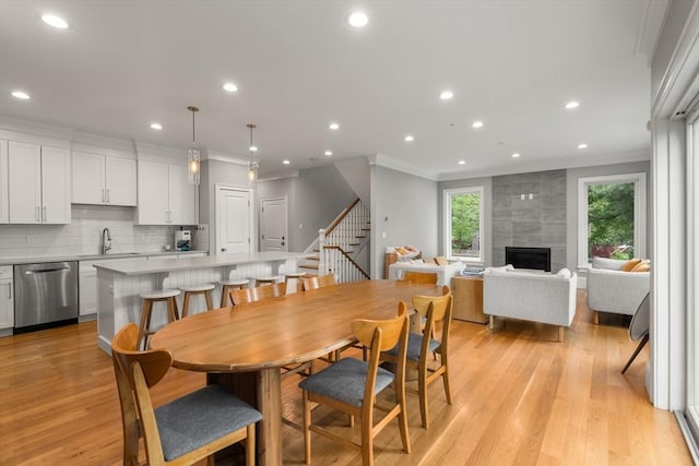 2 Rockwood Ter Unit 2, Newton, MA 02466 - dining space featuring ornamental molding, light wood-style floors, recessed lighting, stairs, and a fireplace