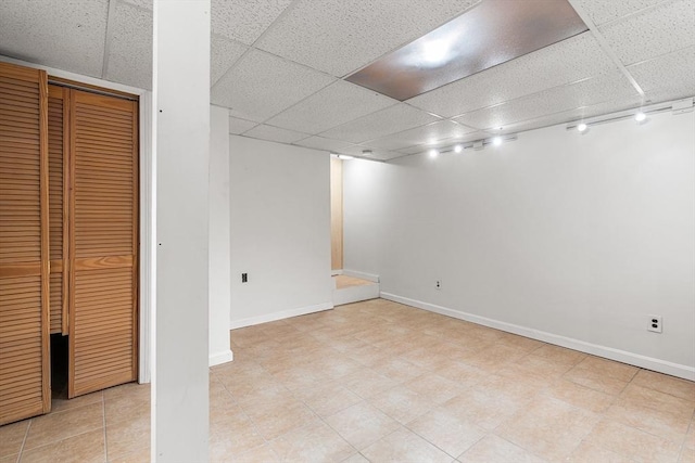 finished below grade area featuring baseboards and a drop ceiling