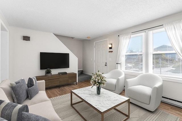 living room featuring a textured ceiling, wood finished floors, and a baseboard radiator