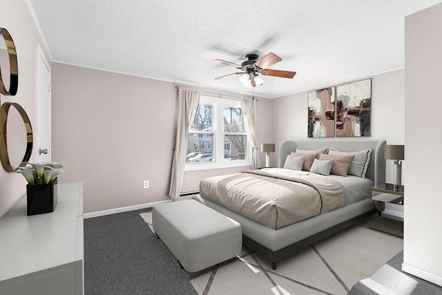 bedroom featuring baseboards, a textured ceiling, a ceiling fan, and ornamental molding