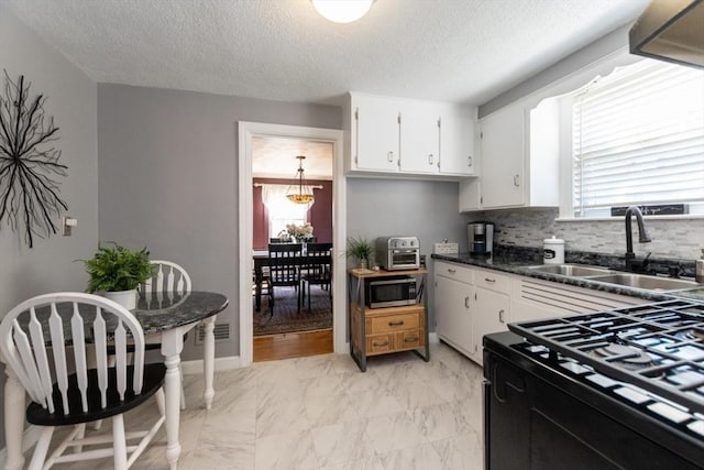 kitchen featuring white cabinets, sink, and a textured ceiling