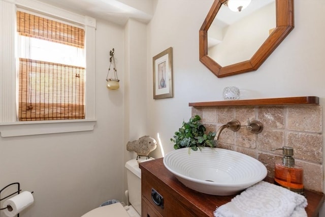 bathroom with backsplash, vanity, and toilet