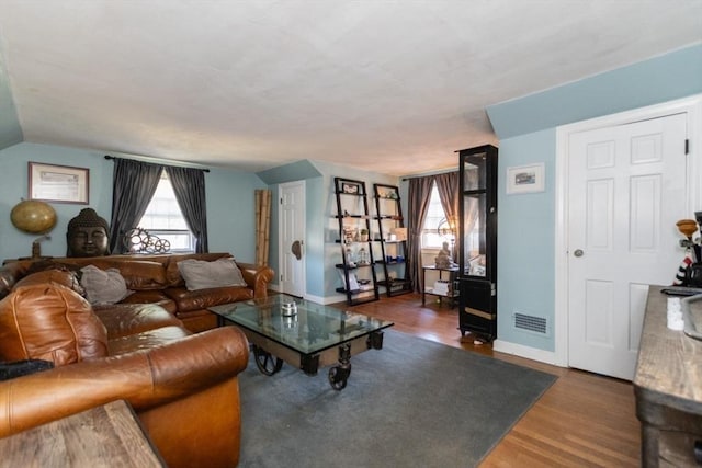 living room with dark hardwood / wood-style flooring and vaulted ceiling