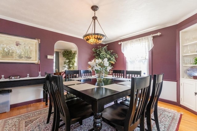 dining room featuring ornamental molding and light wood-type flooring