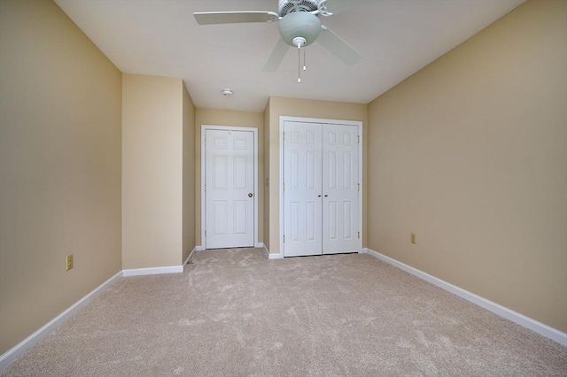 unfurnished bedroom featuring light carpet, ceiling fan, a closet, and baseboards