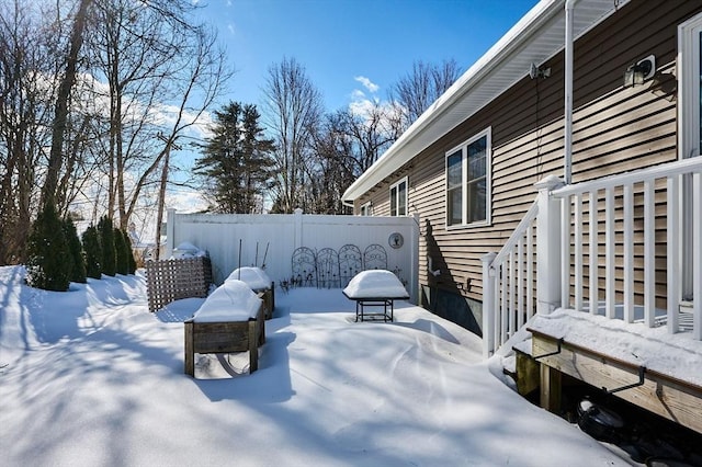 yard layered in snow featuring fence