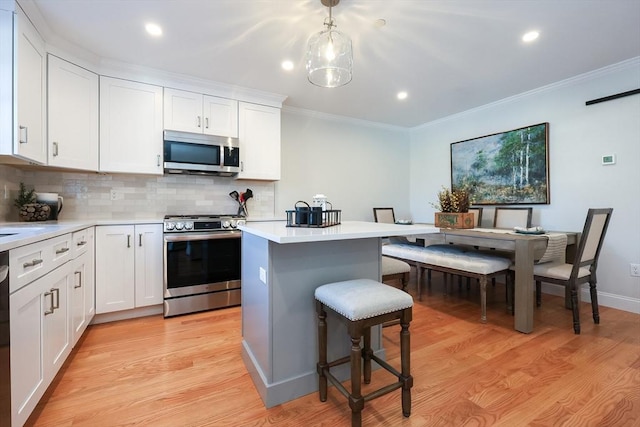 kitchen with stainless steel appliances, backsplash, white cabinets, and a kitchen island