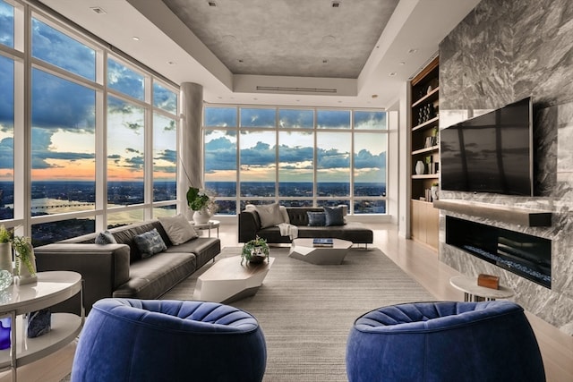 living room with expansive windows, a high end fireplace, and wood-type flooring