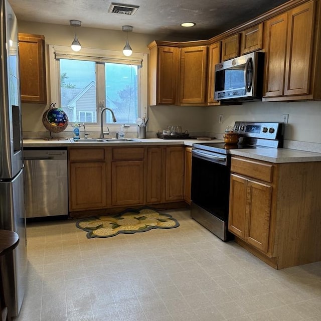 1928 N Main St Unit 4, Fall River, MA 02720 - kitchen featuring appliances with stainless steel finishes, brown cabinets, light countertops, recessed lighting, and hanging light fixtures