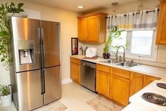 kitchen featuring sink, light tile patterned floors, and stainless steel appliances