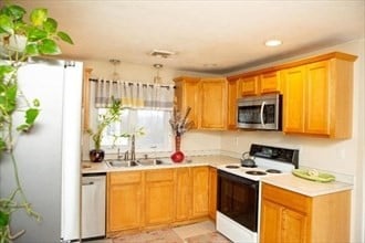 kitchen with appliances with stainless steel finishes, light tile patterned floors, and sink