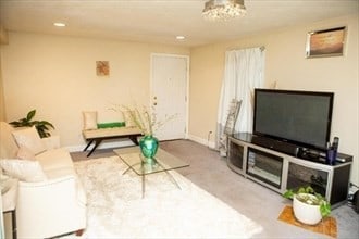 living room with a chandelier and light colored carpet