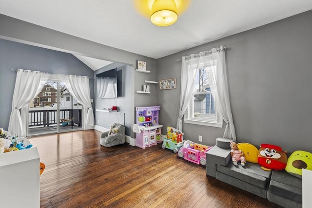 playroom featuring wood-type flooring, vaulted ceiling, and baseboards