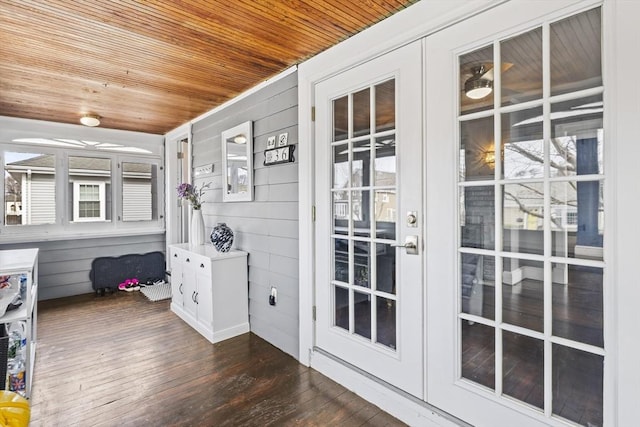 entryway featuring wooden ceiling, wooden walls, dark wood-type flooring, and french doors