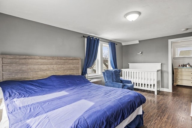 bedroom with dark wood-type flooring and baseboards