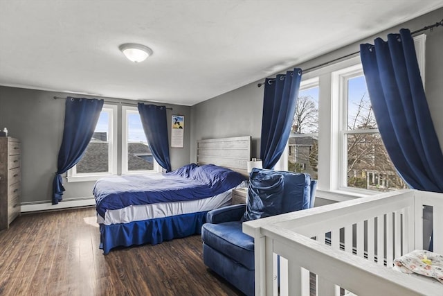 bedroom featuring multiple windows, a baseboard heating unit, and dark wood-style flooring