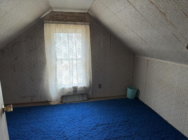 bonus room with vaulted ceiling and carpet