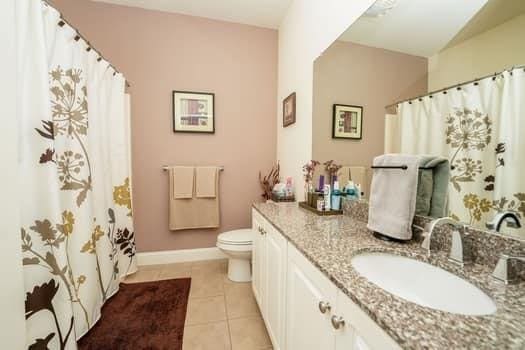 bathroom with toilet, tile patterned flooring, and vanity