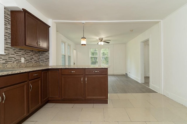 1194 Thorndike St, Palmer, MA 01069 - kitchen with a peninsula, a ceiling fan, decorative backsplash, pendant lighting, and light stone countertops