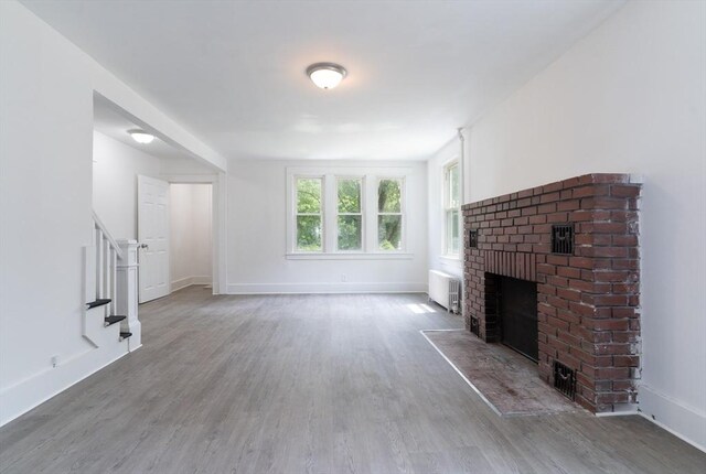 1194 Thorndike St, Palmer, MA 01069 - unfurnished living room with radiator, a brick fireplace, and wood finished floors