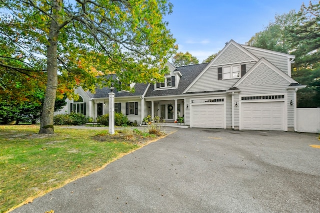 view of front of house featuring a porch, a front yard, and a garage