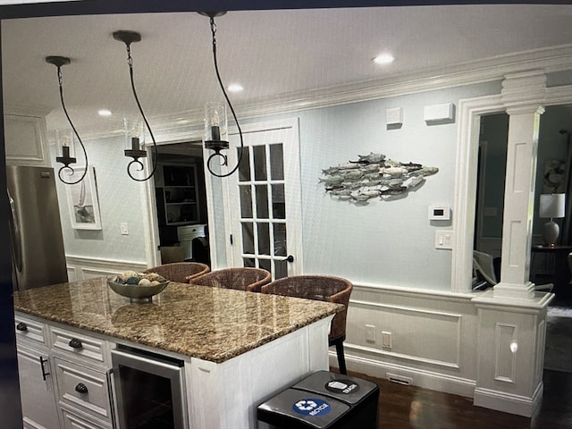 kitchen featuring stone counters, a kitchen island, dark hardwood / wood-style flooring, white cabinetry, and wine cooler