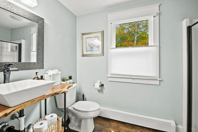 bathroom with toilet, a baseboard heating unit, walk in shower, and hardwood / wood-style floors