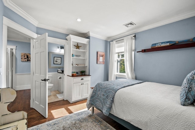 bedroom featuring ornamental molding, hardwood / wood-style floors, and connected bathroom