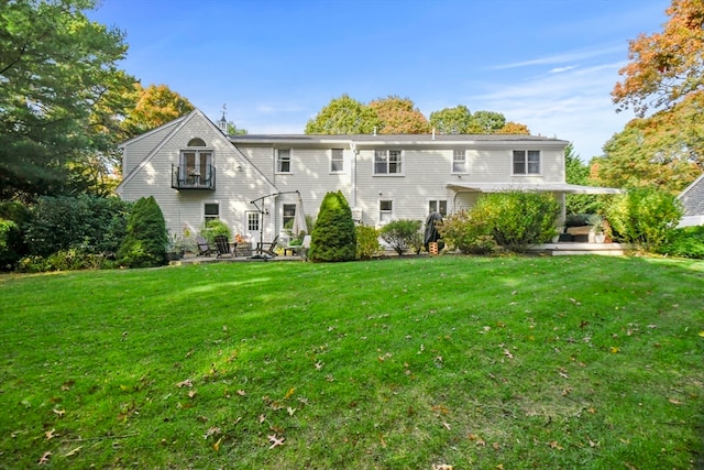 rear view of house featuring a patio and a lawn