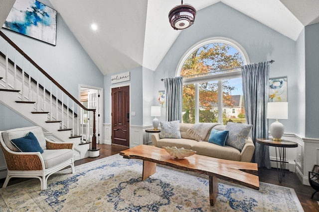 living room with dark hardwood / wood-style flooring, baseboard heating, high vaulted ceiling, and plenty of natural light