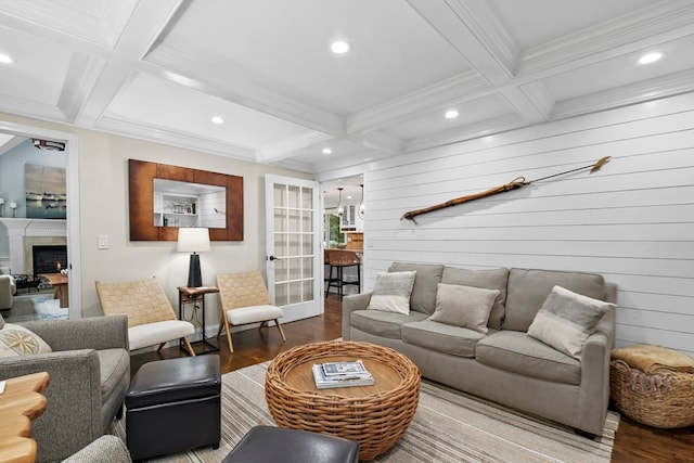 living room with wood walls, hardwood / wood-style flooring, beamed ceiling, and coffered ceiling