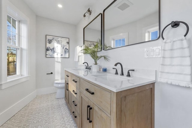 bathroom with toilet, tile patterned floors, a wealth of natural light, and vanity