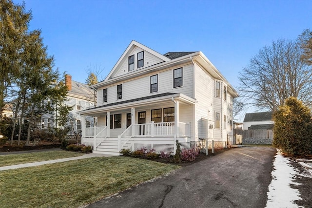 view of front of property with covered porch and a front yard