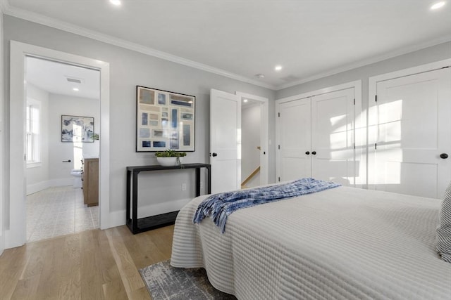 bedroom with light hardwood / wood-style floors, ensuite bathroom, and ornamental molding